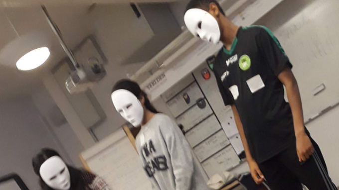 Tre personer med vita ansiktsmasker.
