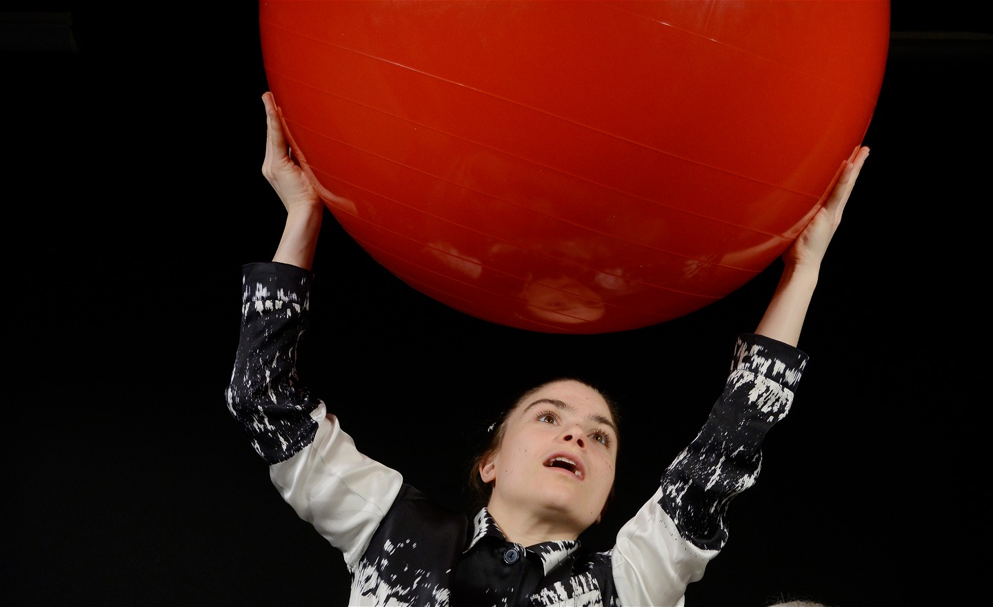 Kvinna håller i stor röd boll i luften
