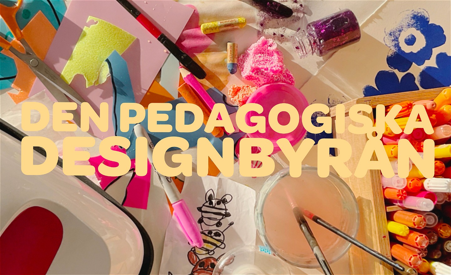 Den Pedagogiska Designbyråns logga visas i bakgrunden ser man penslar, kritor och andra konstnärliga material
