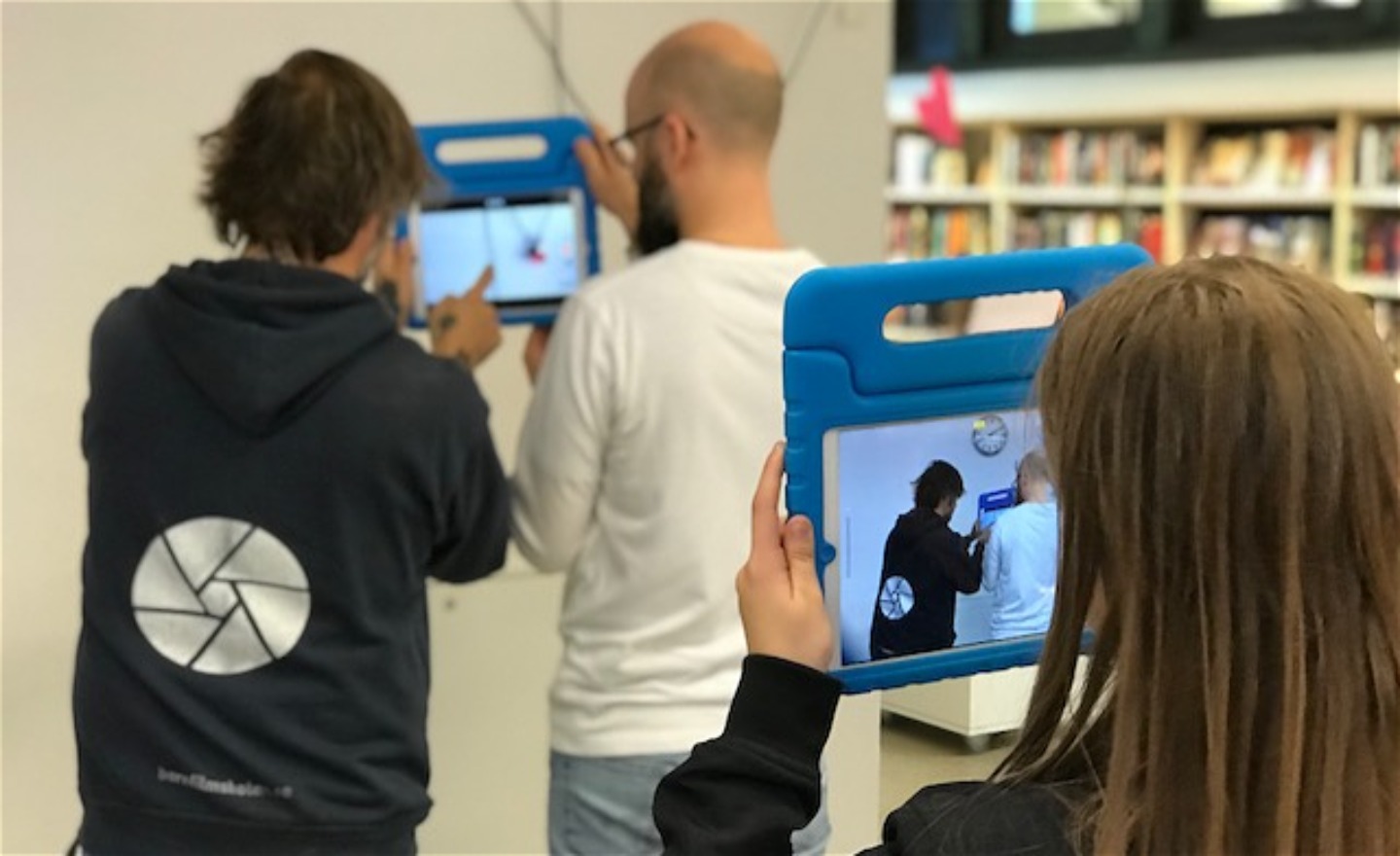 Barn filmar två vuxna som filmar.