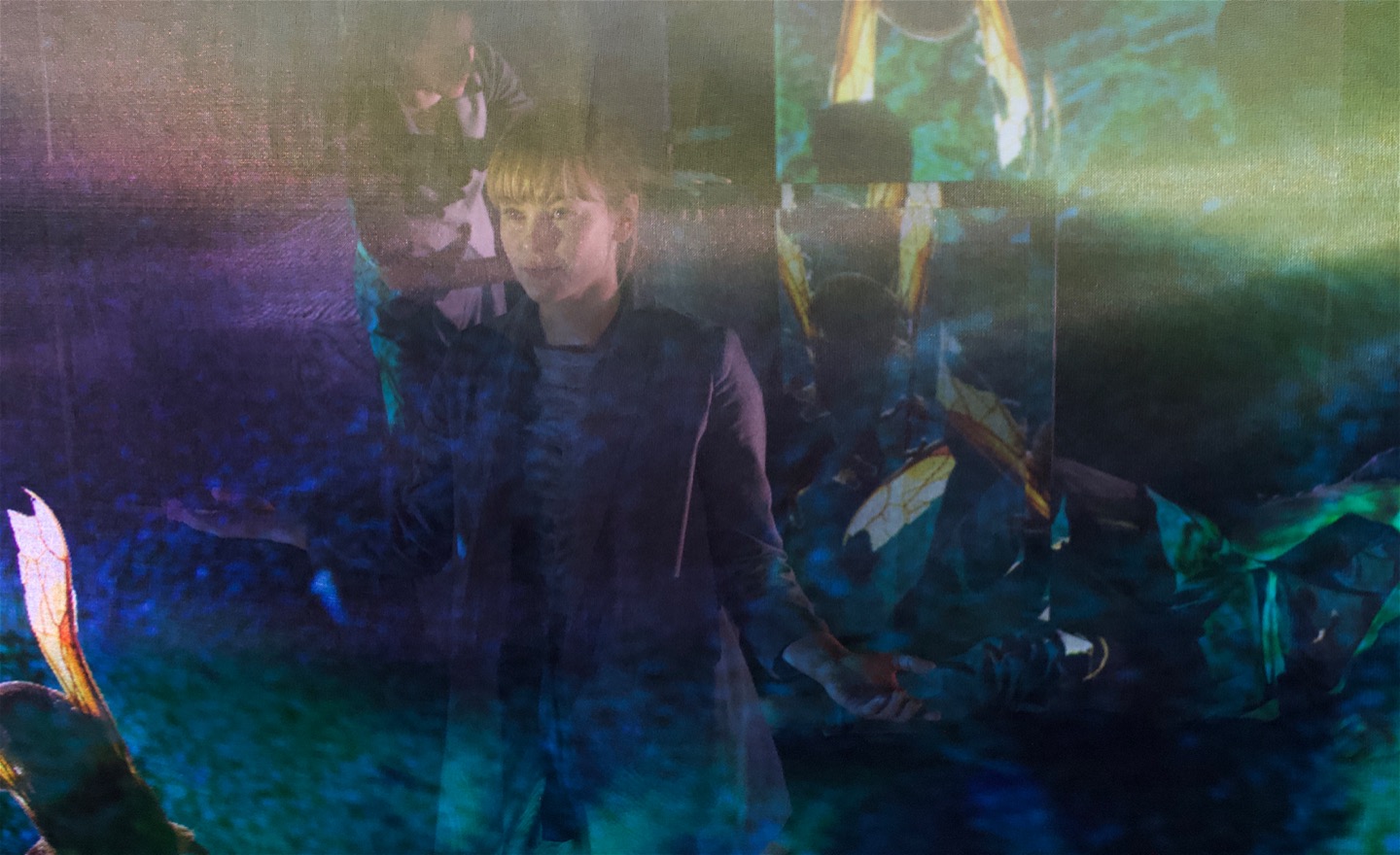 Dansare pratar o rör sig bakom ett grönskimrande nät