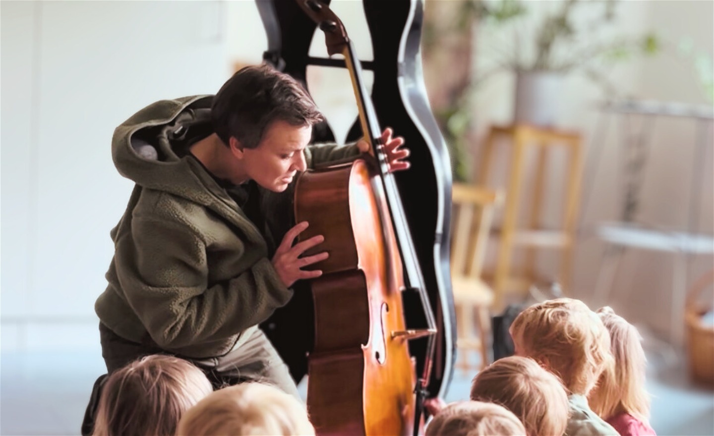 En person visar en cello för en grupp med barn