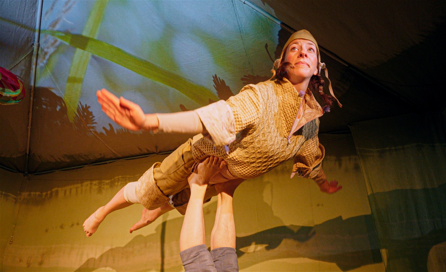 En skådespelerska flyger flygplan på fötterna på en annan akrobat