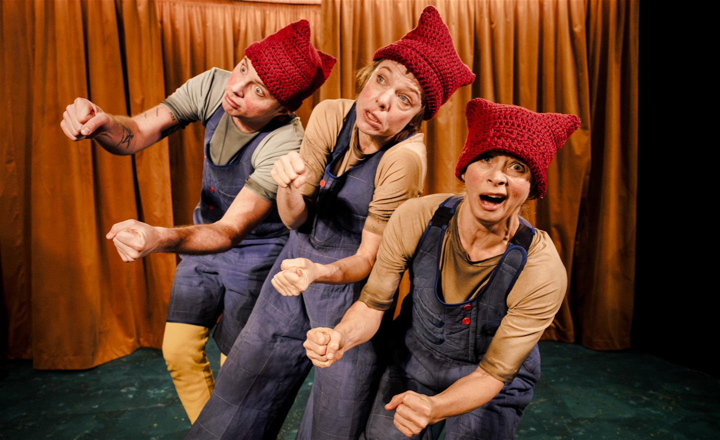 Tre personer i likadana kläder mimar att de kör bil.