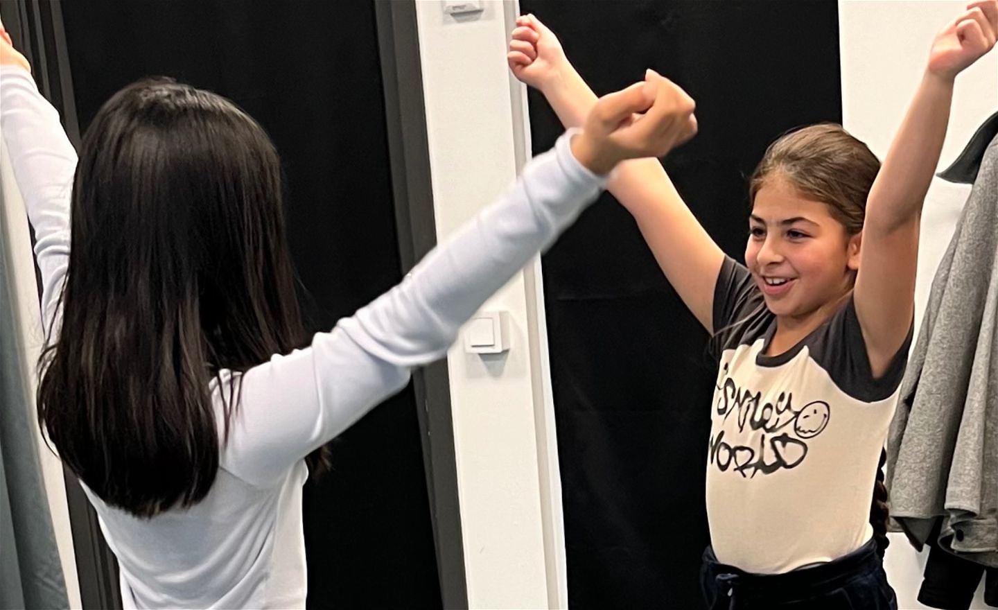 Två personer deltar i en workshop och sträcker upp armarna.