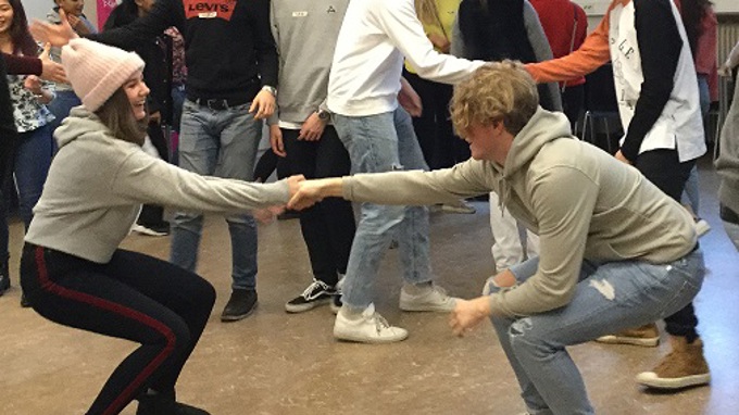 Två personer håller i varandras händer och försöker dra den andre till sig.