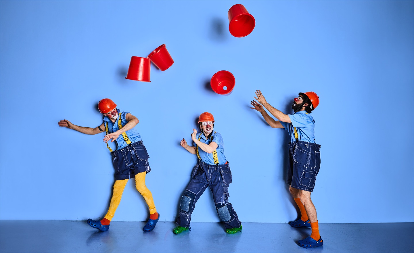 Tre clowner röda hinkar kastas