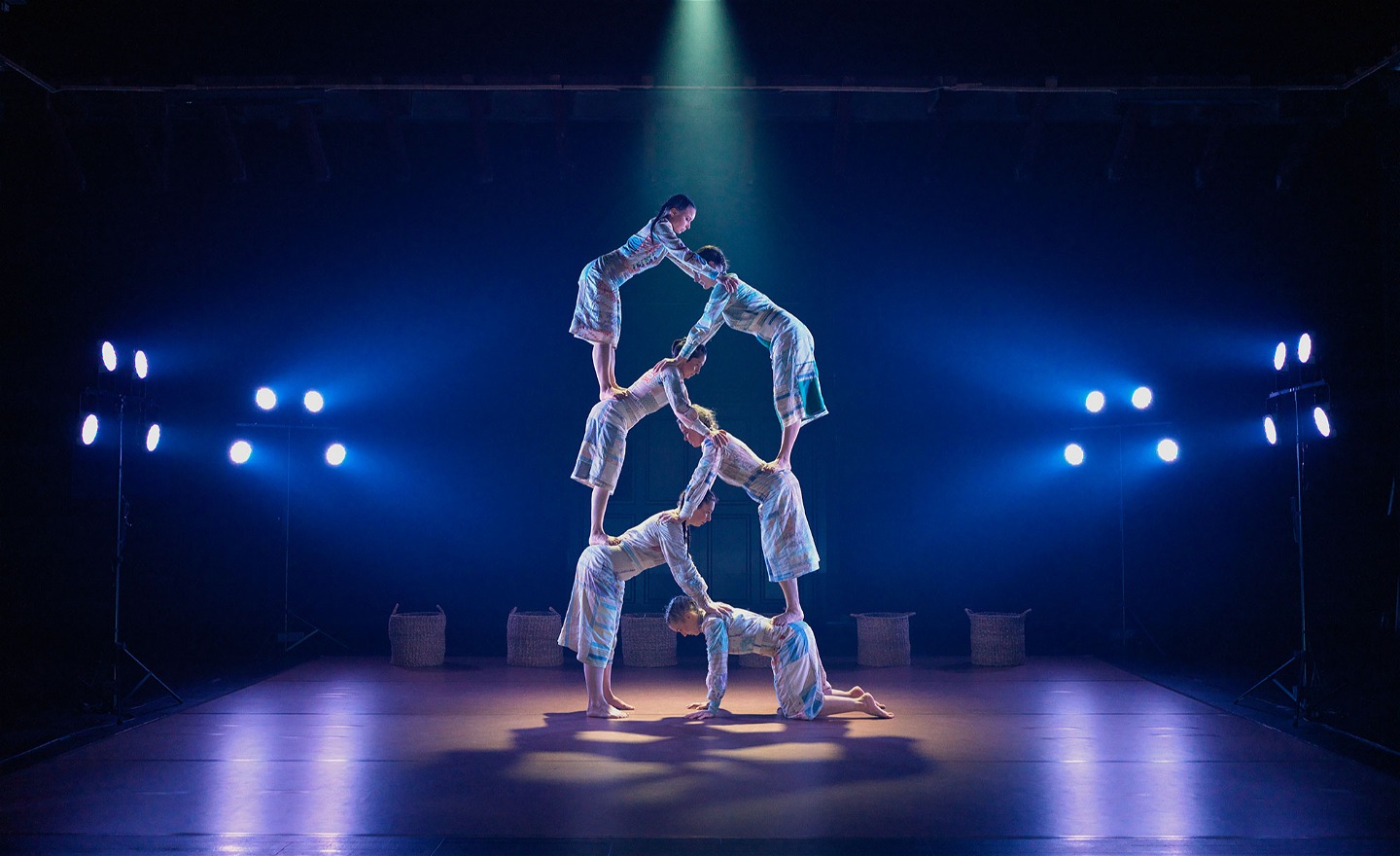 Sex kvinnliga akrobater i en symmetrisk mänsklig pyramid