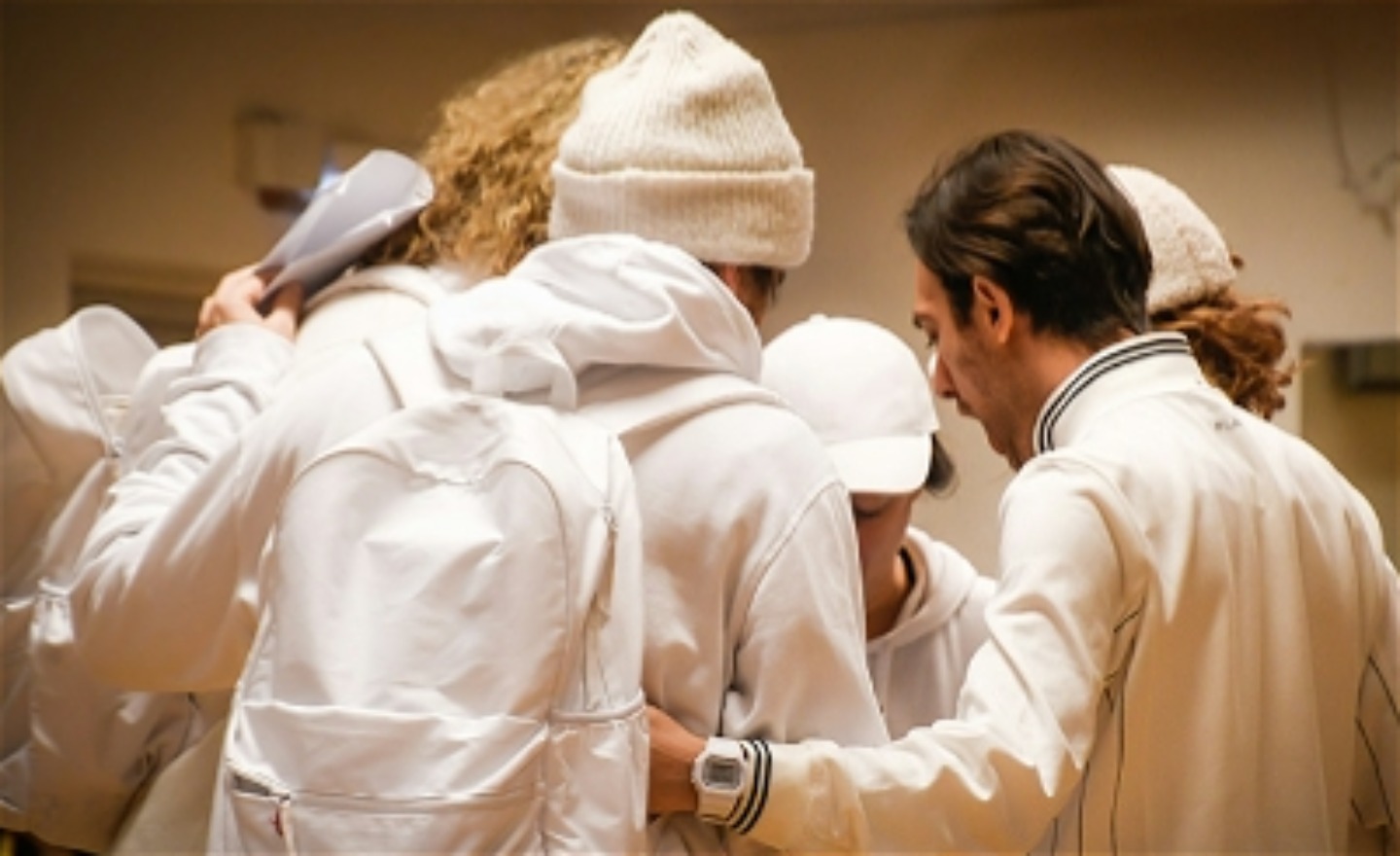 Fem personer i en ring, de håller varandra runt armarna.