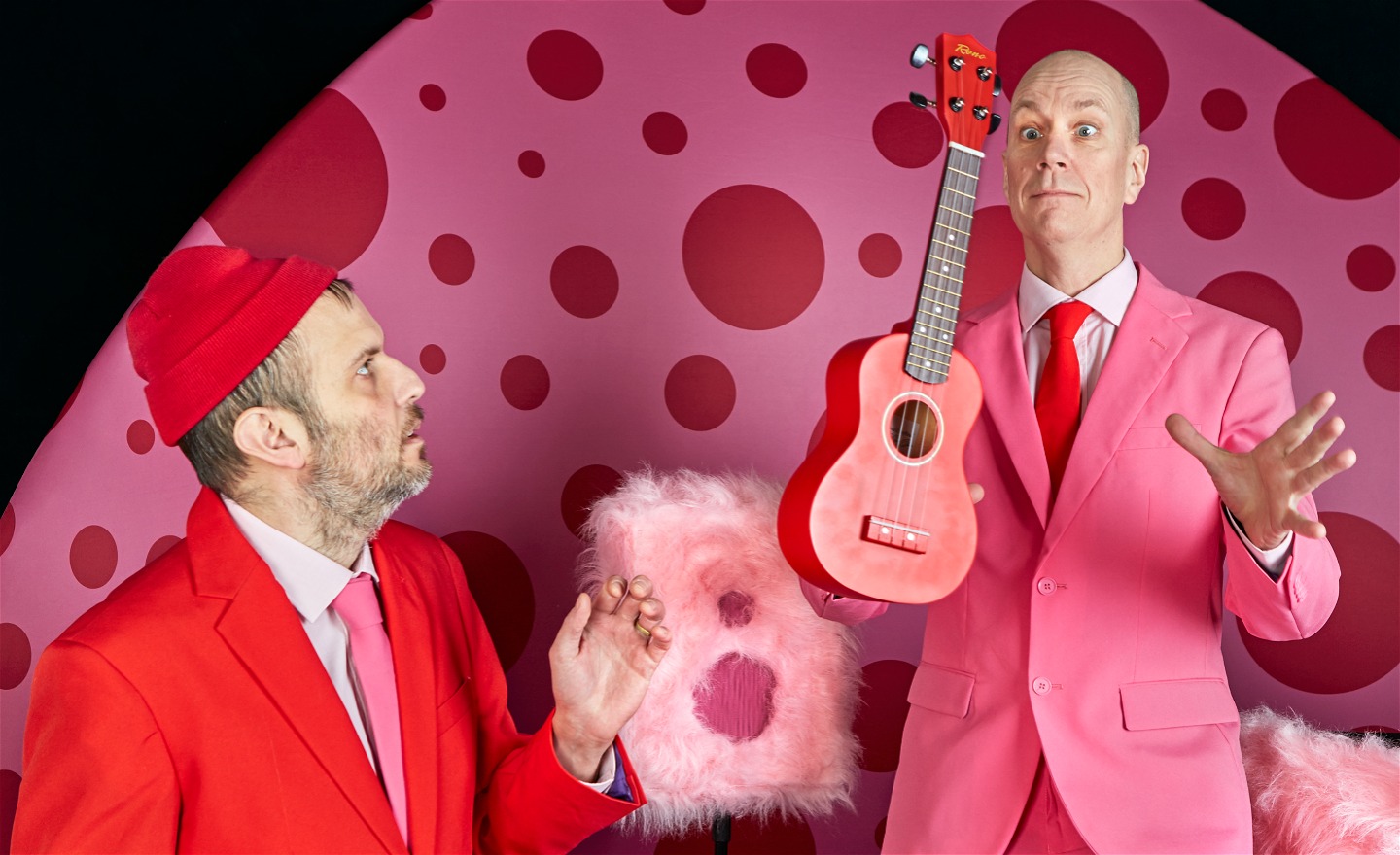 Fredrik Myhr och Per Wernolf i den färgsprakande scenografin. I denna bild försöker Per fånga en ukulele som Fredrik kastar till honom.