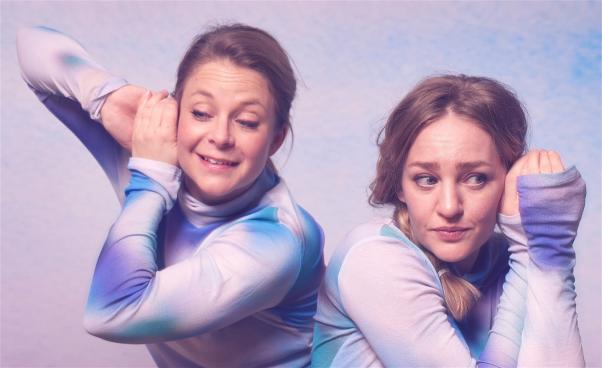 Närbild på två dansare i molnmönstrade tröjor