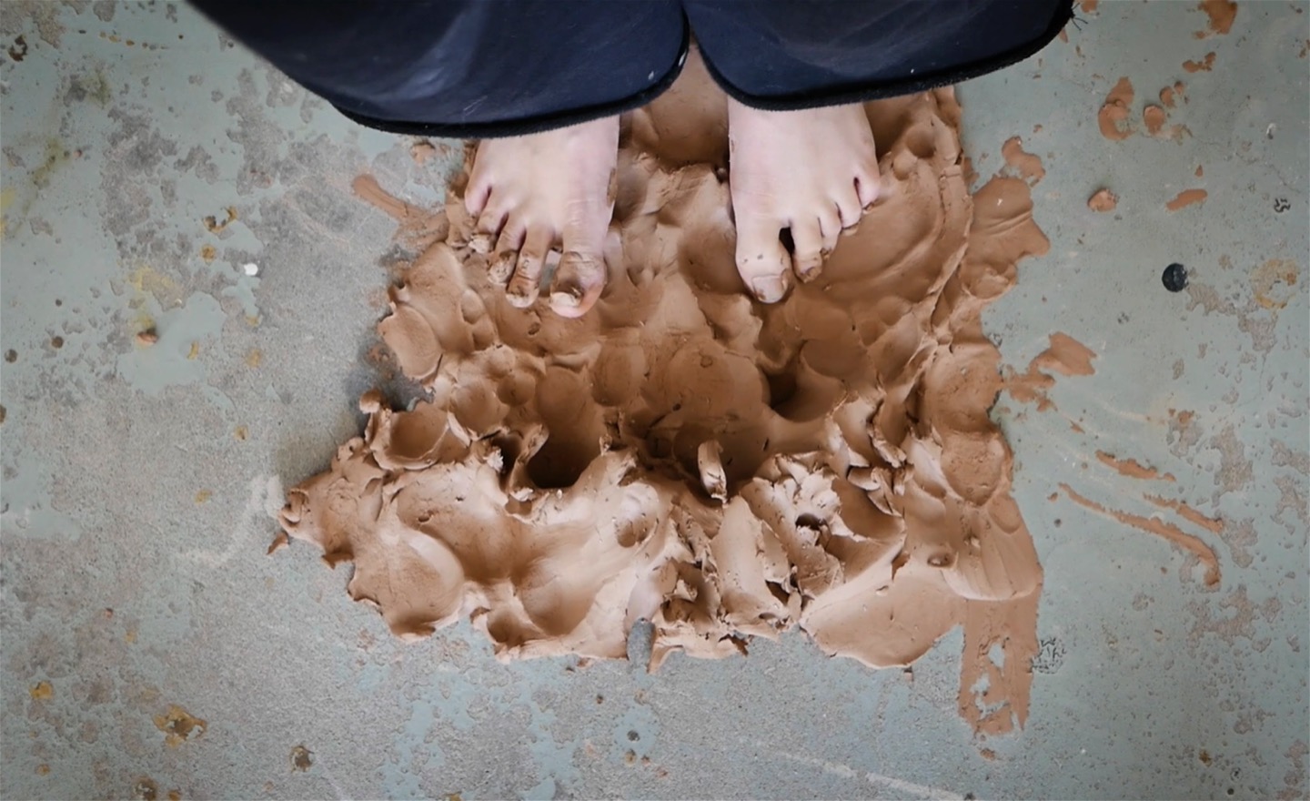 Fötter som står i lera.