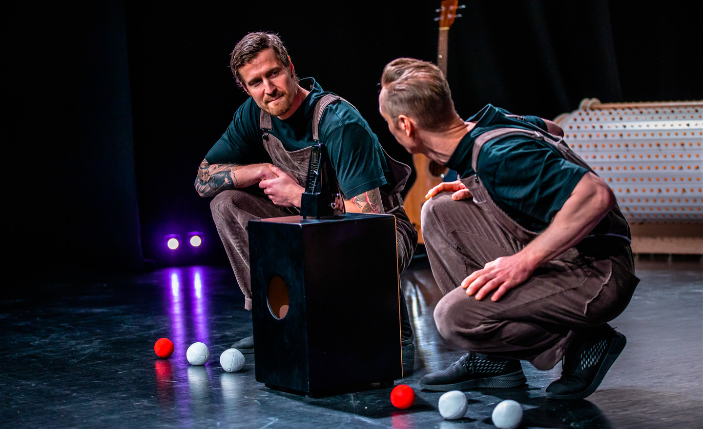 Två jonglörer på scenen, framför en högtalare. I bakgrunden syns deras vita musikmaskin.