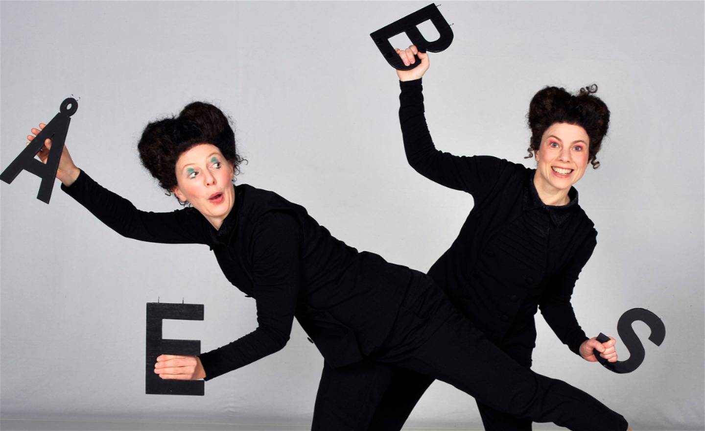 Sanna och Inger dansar med bokstäverna Å, B, E och S. De håller bokstäverna i händerna.