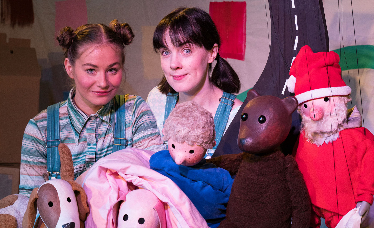 Bilden visar skådespelarna Cajsa Tornfors och Rebecka Carlsson med alla dockorna ur föreställningen.