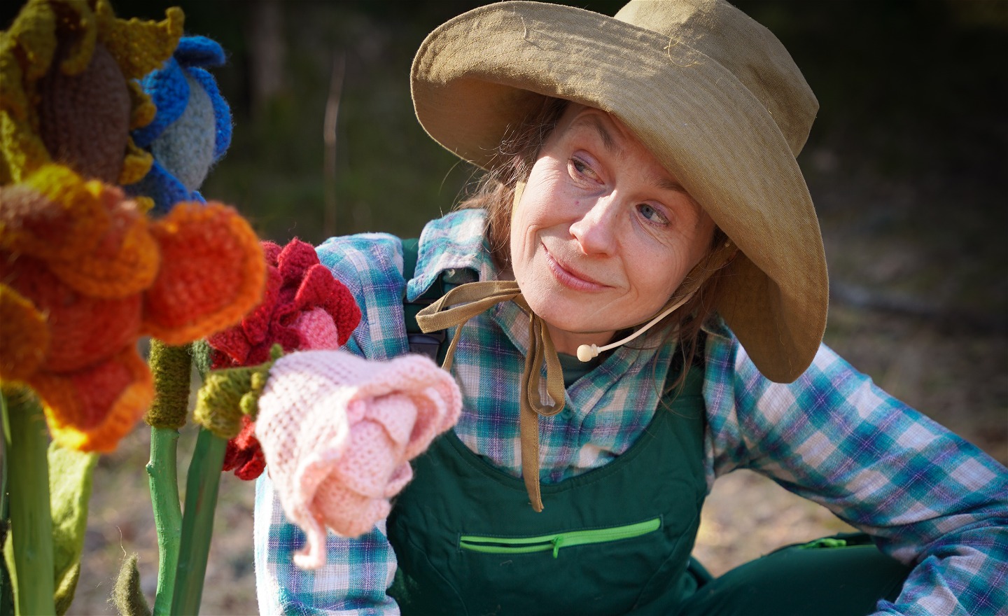 Färglada virkade blommor och en trädgårdsmästare med hatt