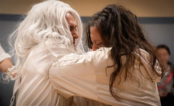 Vitklädda personer kramar varandra