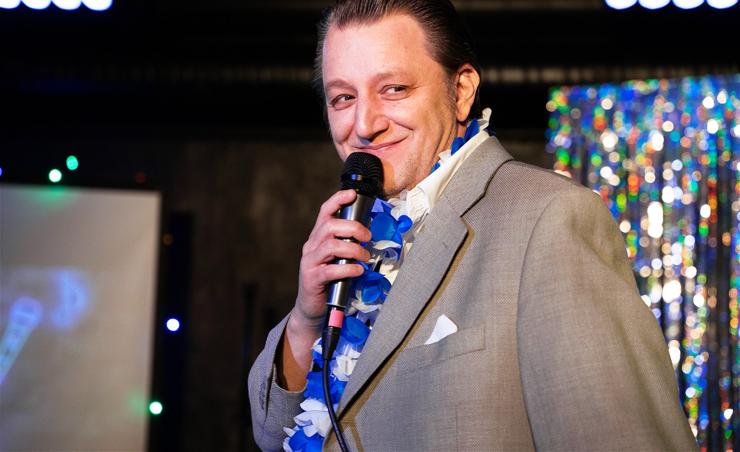 En leende trubadur med mikrofon