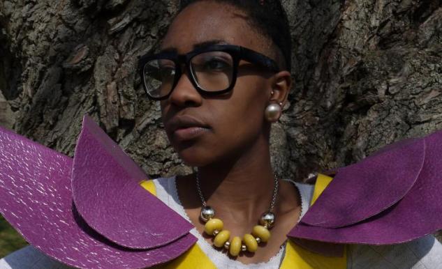 Porträtt av en kvinna med glasögon och ett stort halsband.