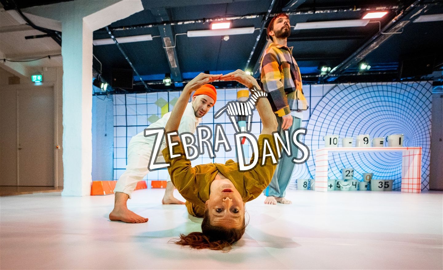 Dansare som är upp och ner, och formar en nolla med sina armar.