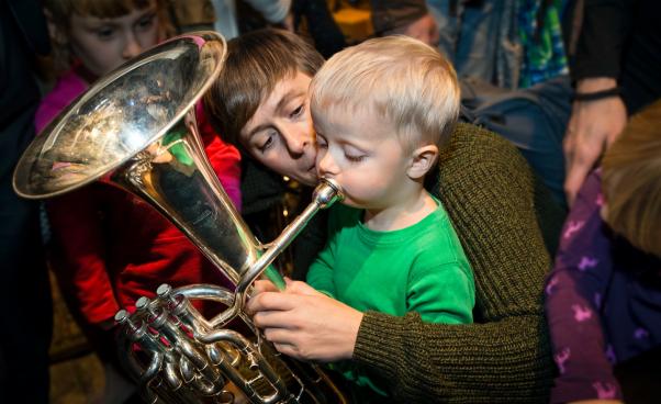 En pojke blåser i ett bläckblåsinstrument.