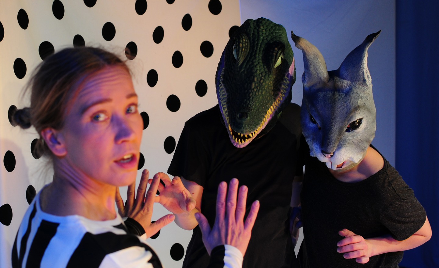 tre dansare, två har på sig djurmasker