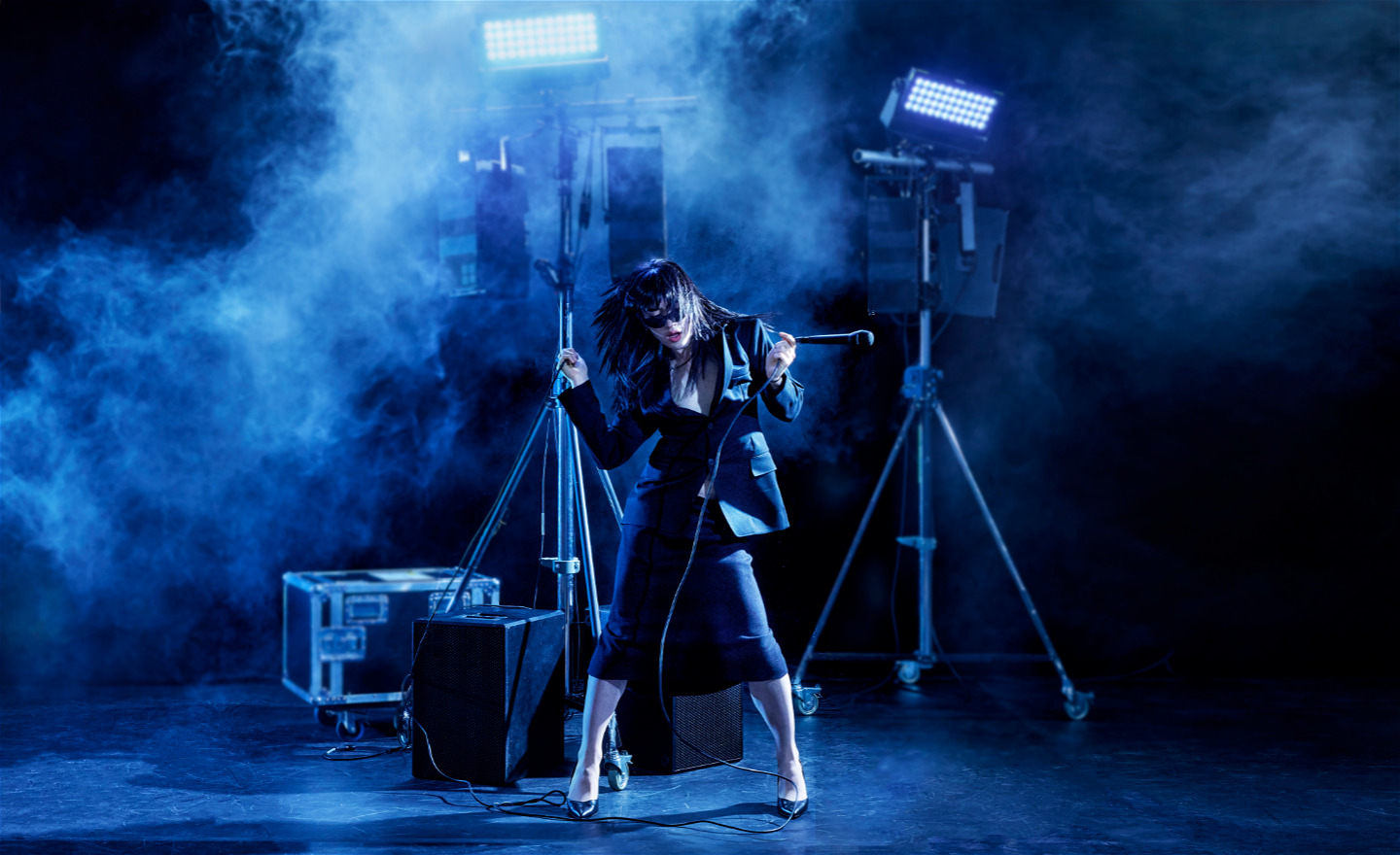 Kvinnlig rockstjärna på scen i blått ljus