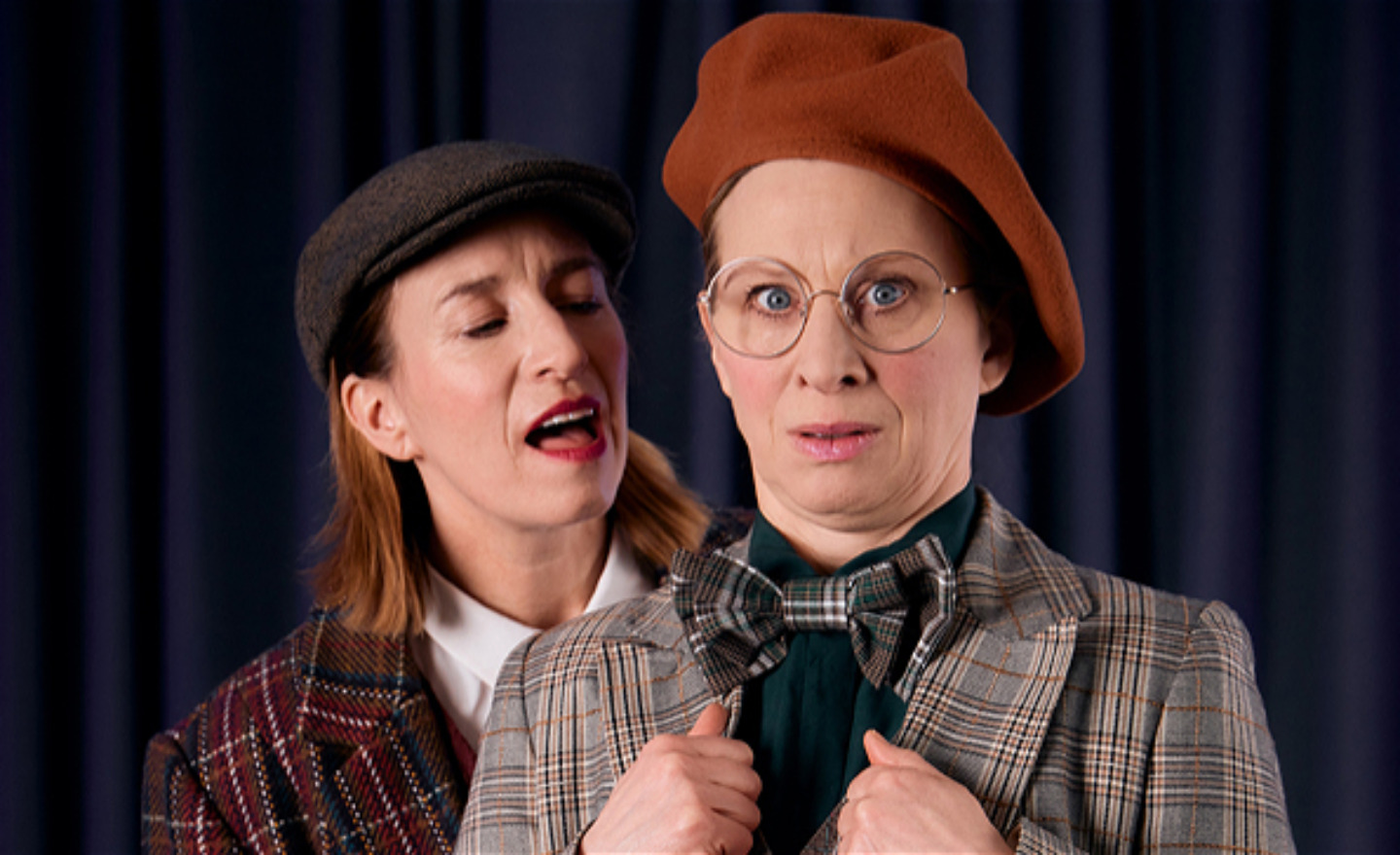 Två skådespelare i rutiga kläder.