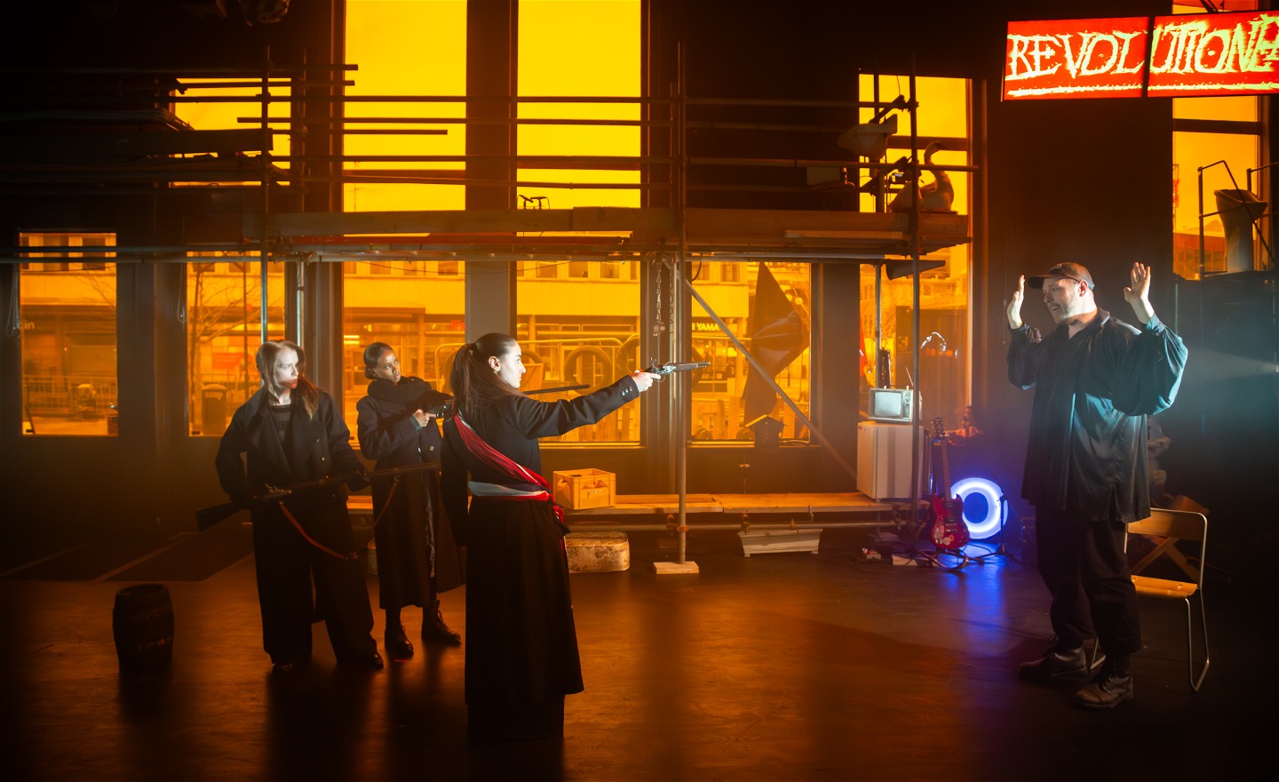 En kvinna riktar en pistol mot en man 