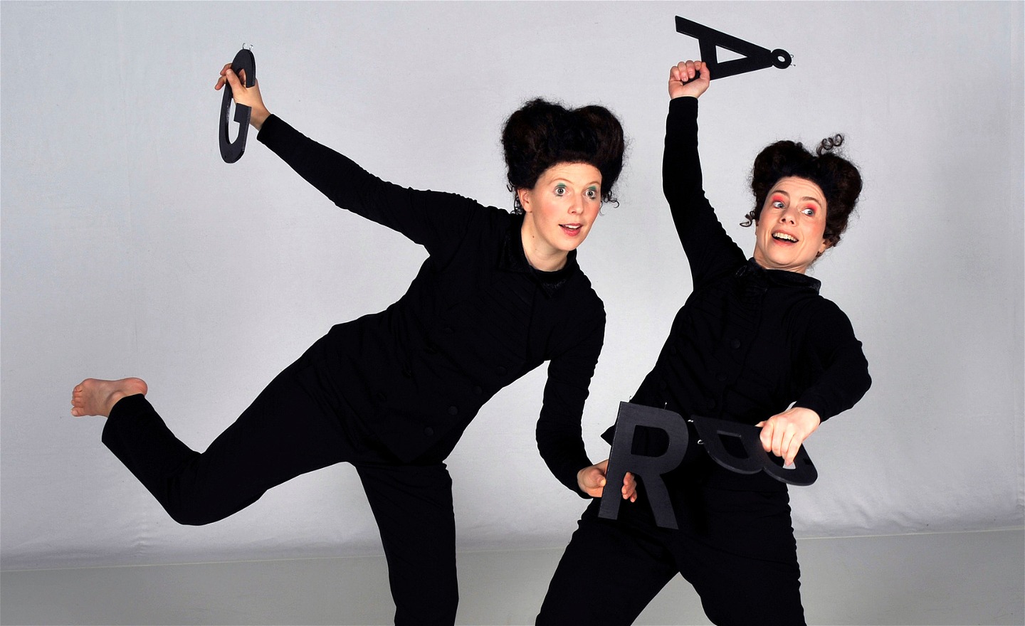 Sanna och Inger dansar med bokstäverna G, R, Å och B i händerna.