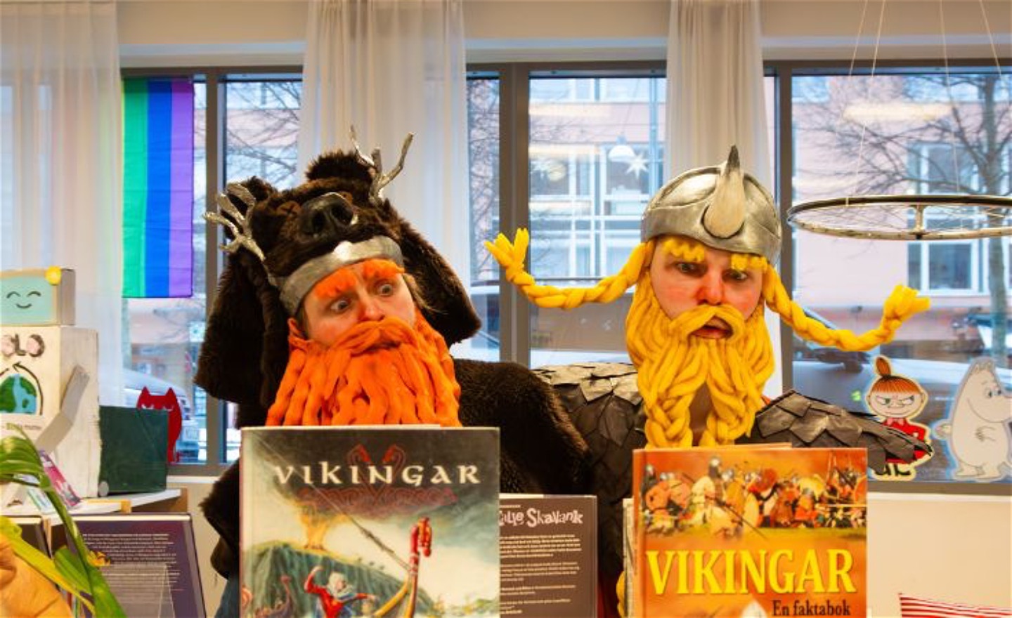 Två vikingar i ett bibliotek  ser förvånade ut när de ser faktaböcker om vikingar
