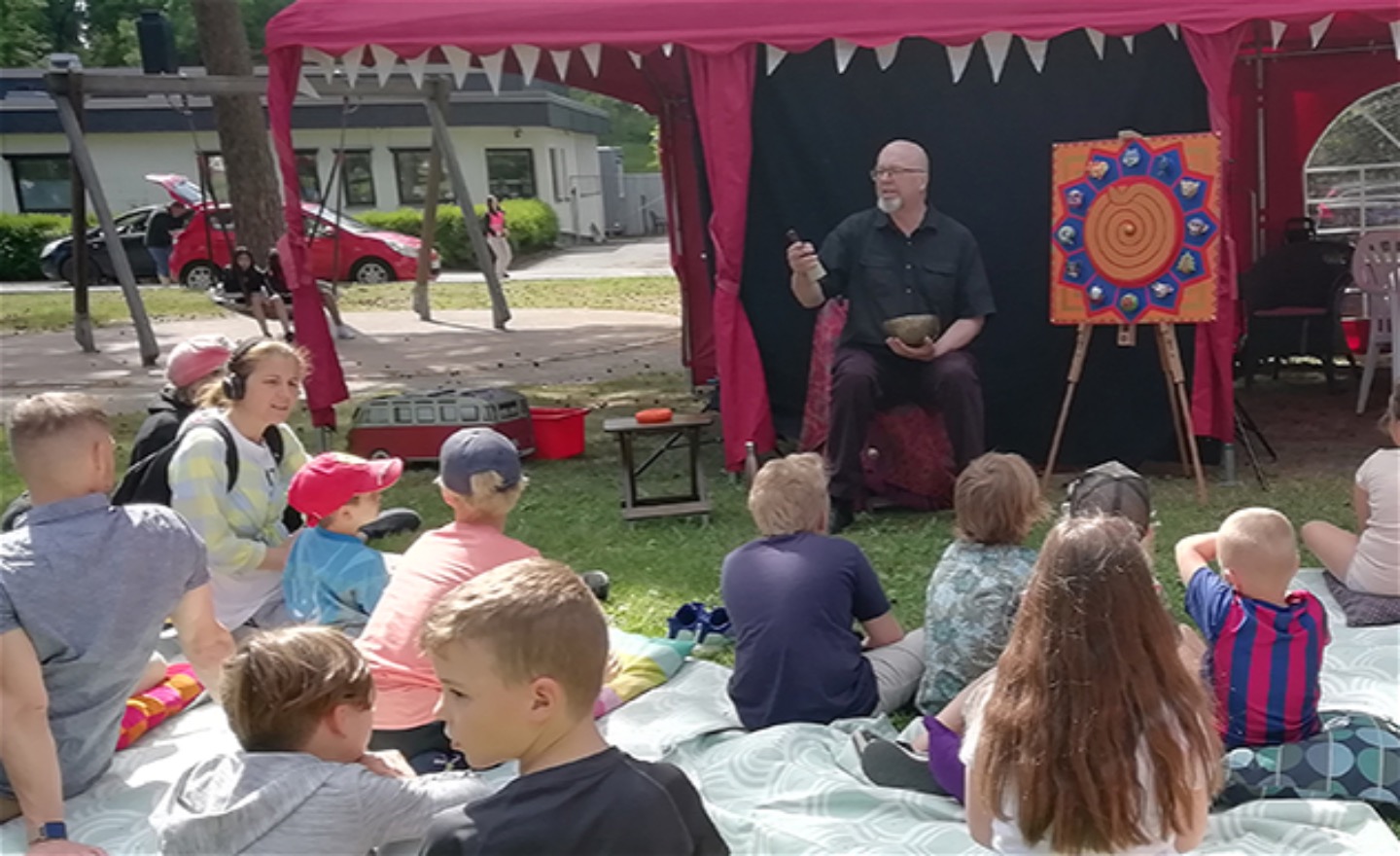 Berättaren sitter i ett tält med många barn framför sig.