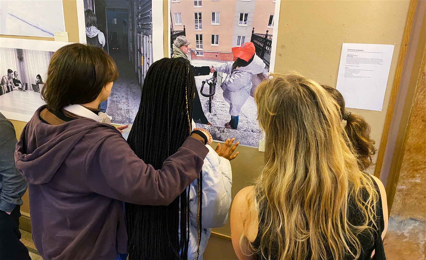 Elever på vernissage i skolan tittar tillsammans på fotografier från workshop