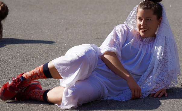 En dansare i bröllopslklänning ligger på marken