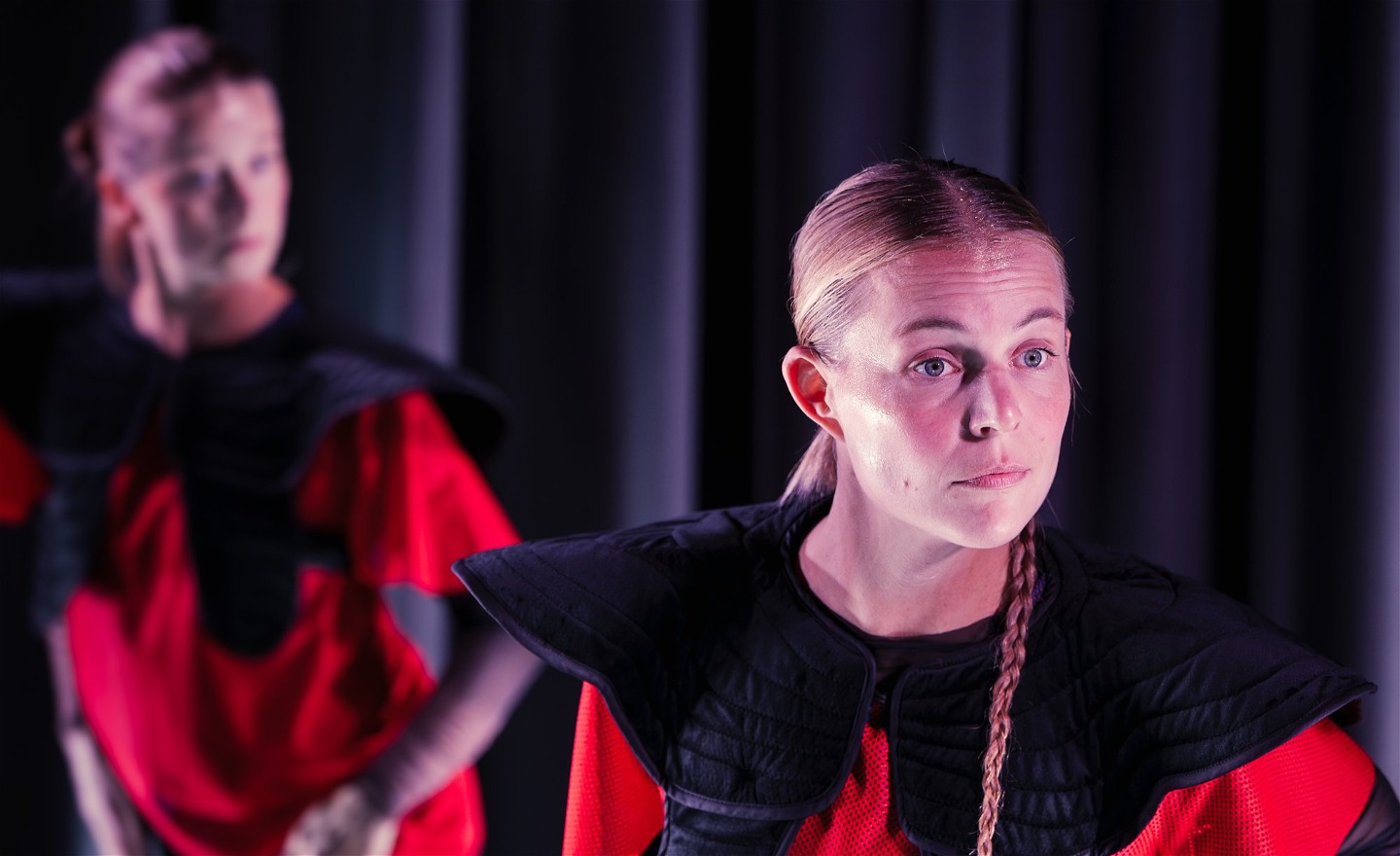 En person är i fokus och en bakgrunden i ofokus på en scen.